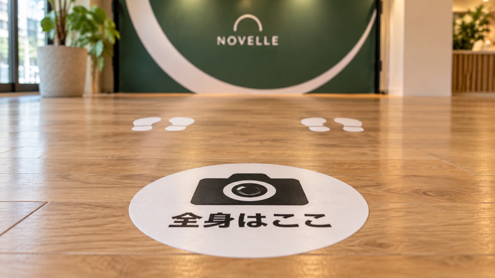 フォトスポットの床に貼った、足跡の形の立ち位置の印と、カメラの形の撮る位置の印を、床に近い低い位置から写した接写